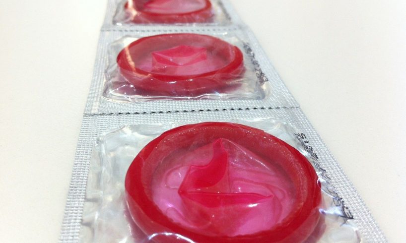 Fire røde kondomer i pakke sidder sammen
